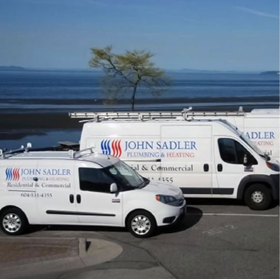 4 John Sadler vans parked in front of the water