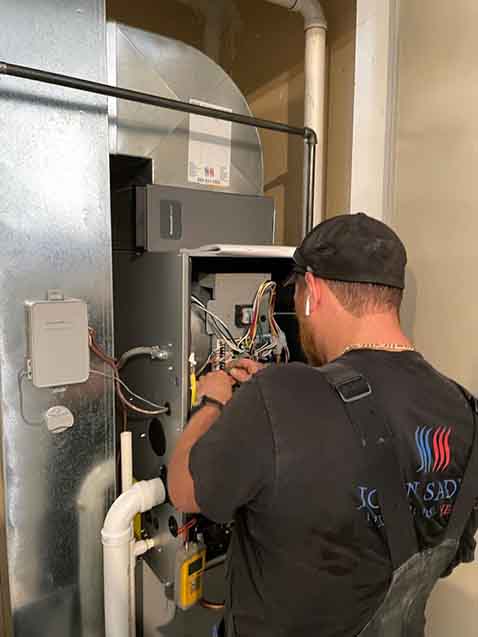 Technician repairing a gas furnace